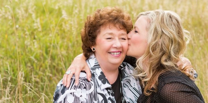 Photo of woman kissing mother on the cheek